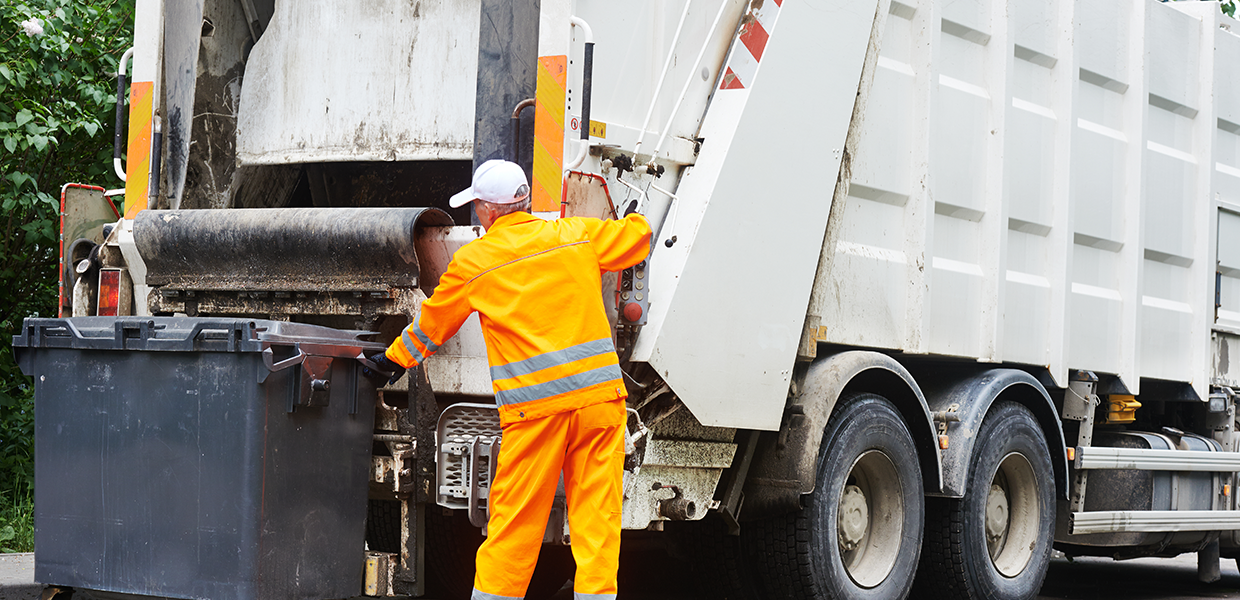 Camion de collecte des ordures en action, où BioService réduit les émissions odorantes.